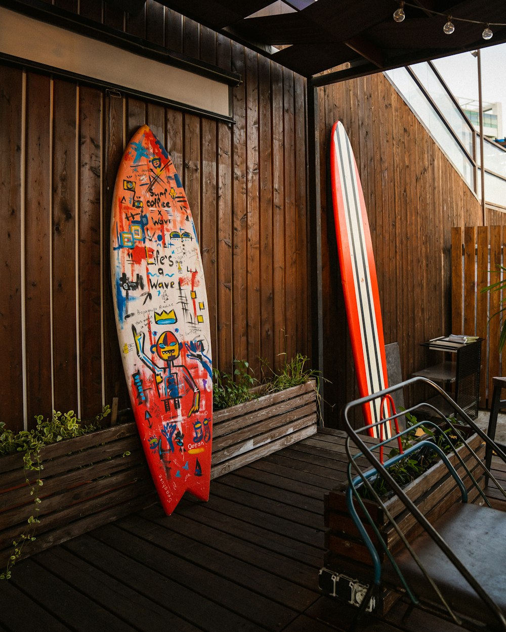 two surfboards leaning against a wooden fence