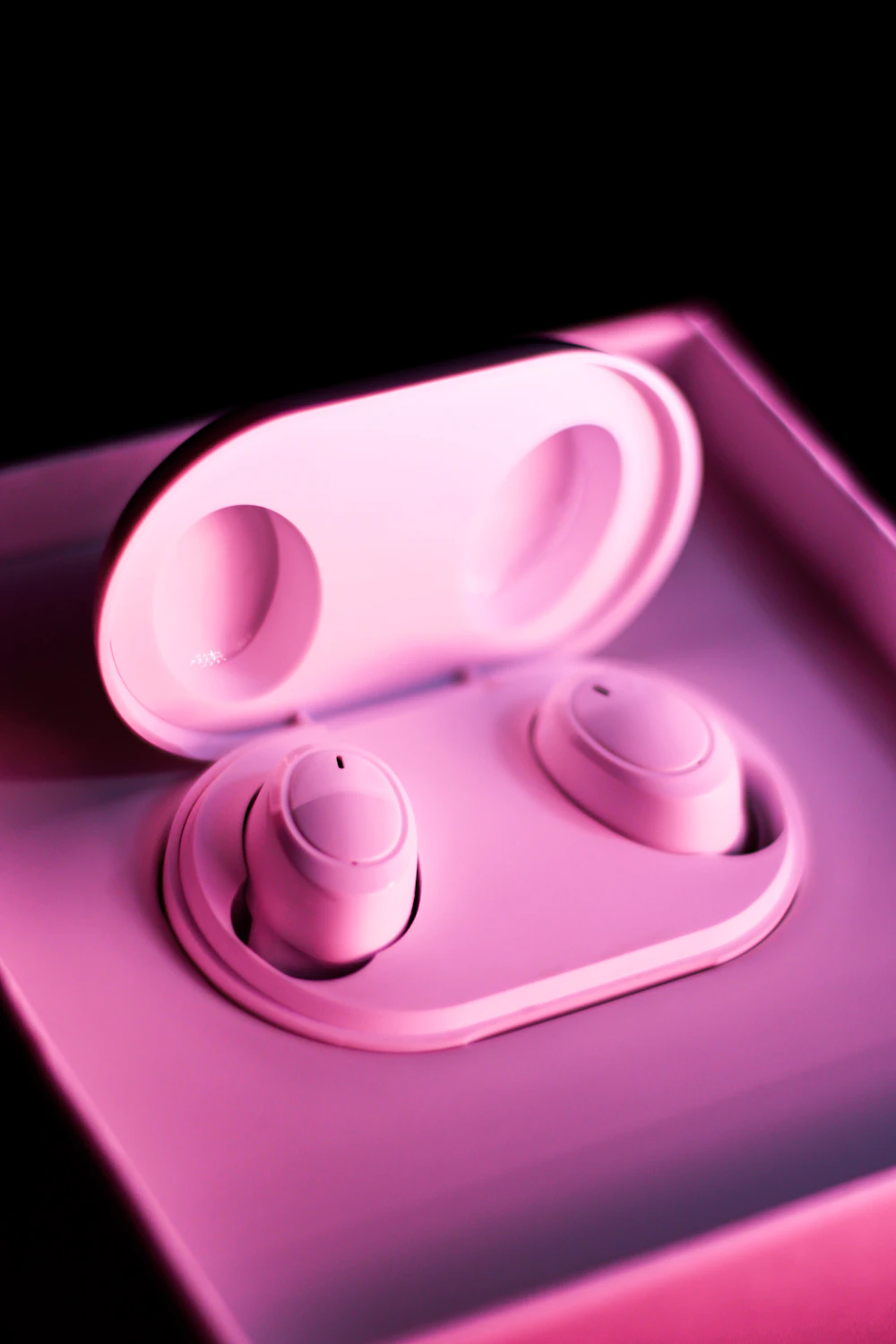 Pink true wireless earbuds in charging case