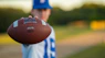 a close up of a person holding a football