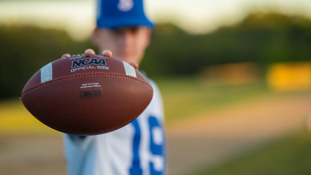 a close up of a person holding a football