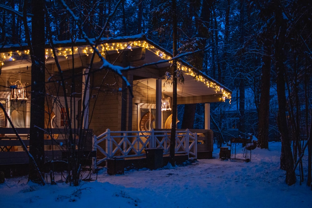 a small cabin is lit up with christmas lights