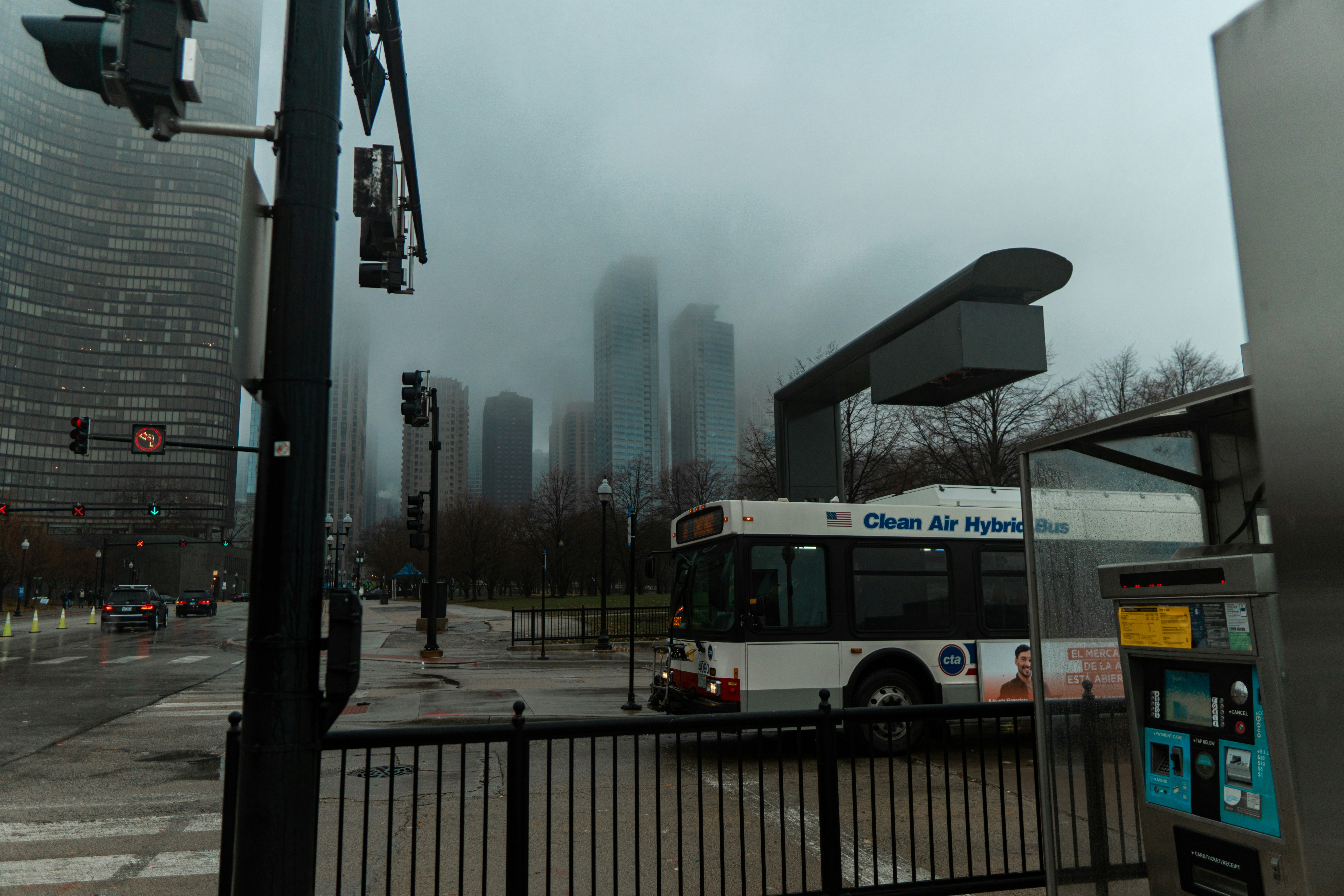 a city bus driving down a street next to tall buildings