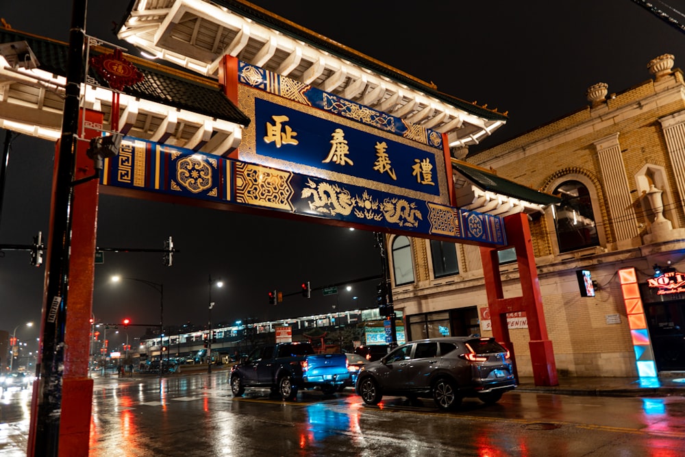 a city street at night with cars parked on the side of the road