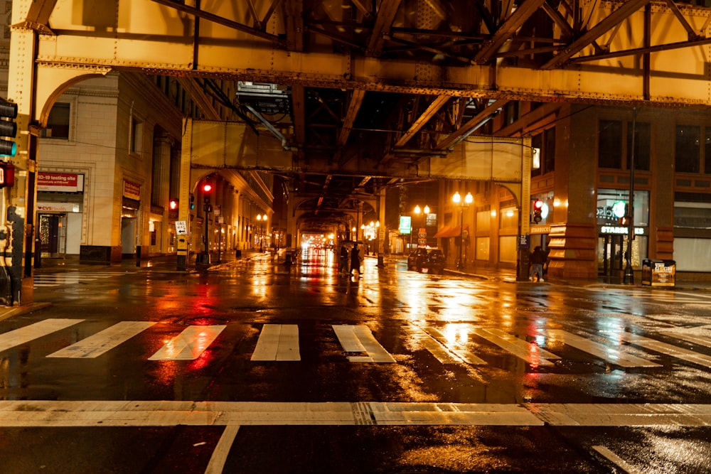 a wet city street at night with traffic lights
