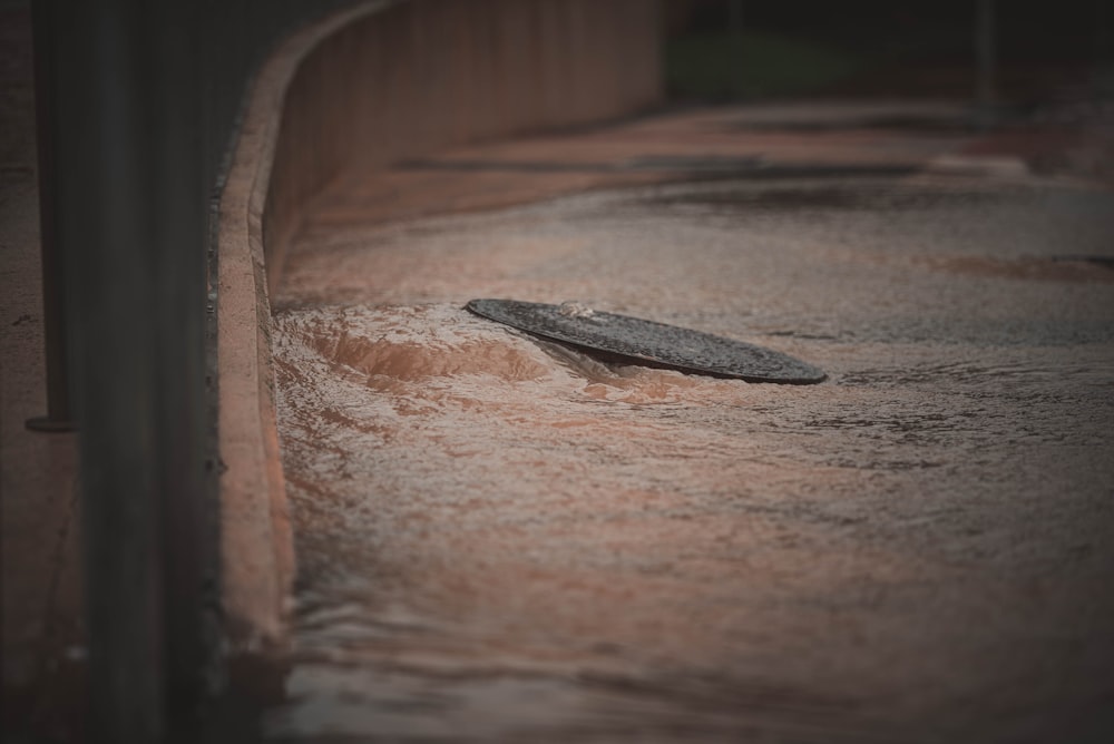 a skateboard laying in the middle of a flooded street