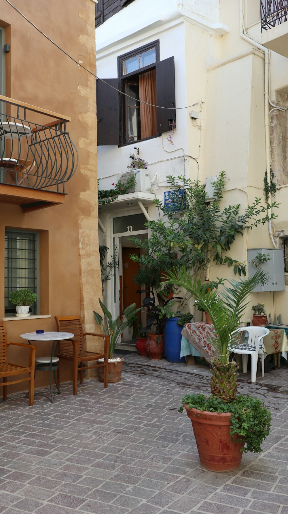 a courtyard with a table and chairs and a balcony