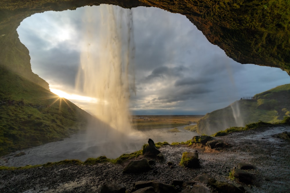 a view of a waterfall from inside a cave