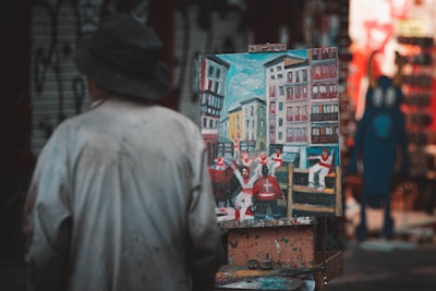 a man walking down a street past a painting