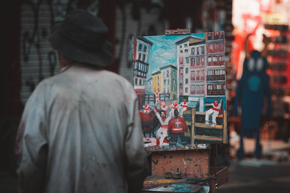 a man walking down a street past a painting
