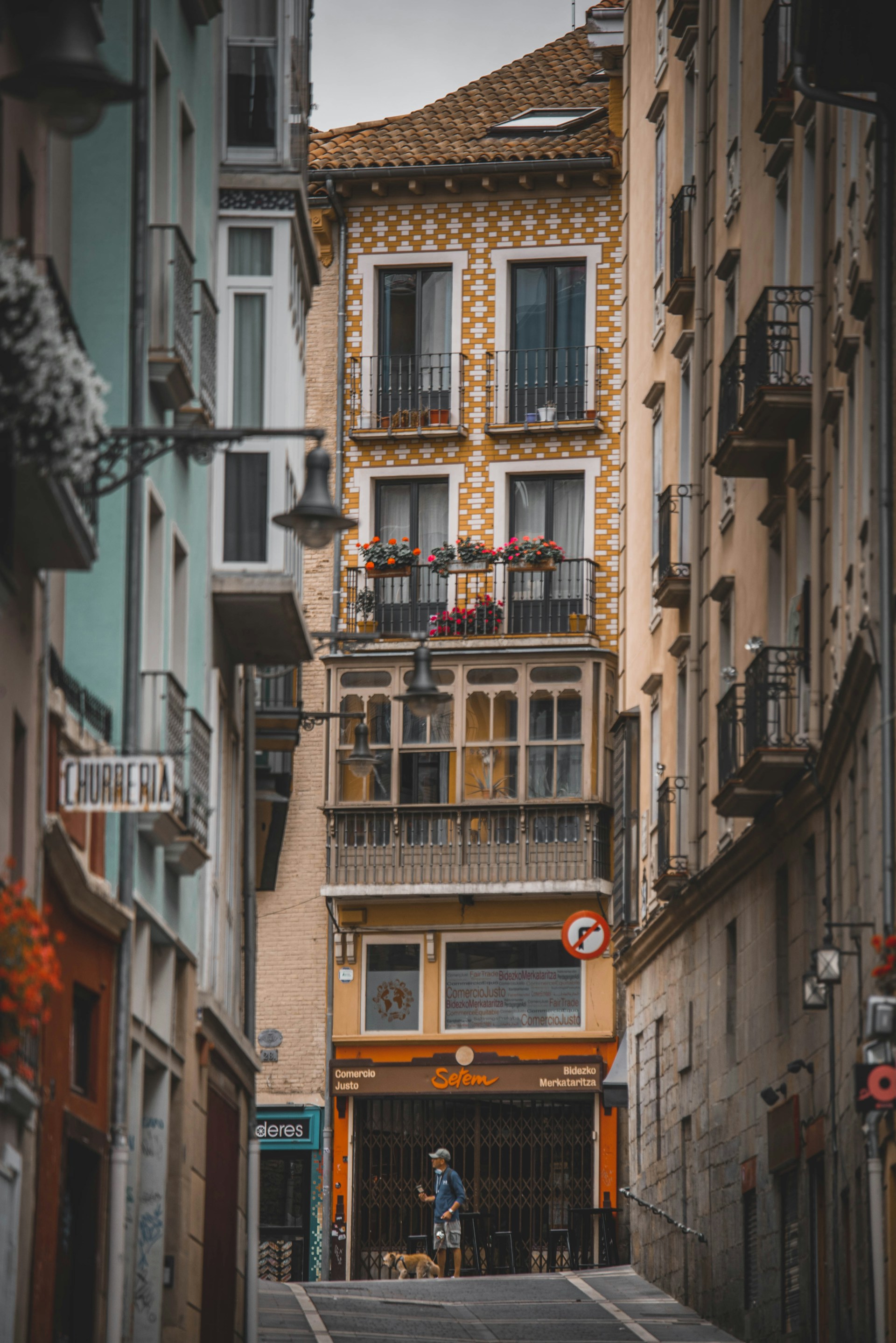 a narrow city street with a tall building in the background