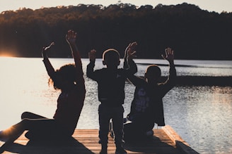 a group of people sitting on top of a wooden dock