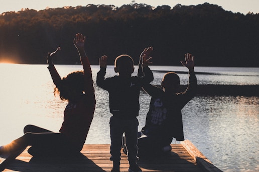 a group of people sitting on top of a wooden dock