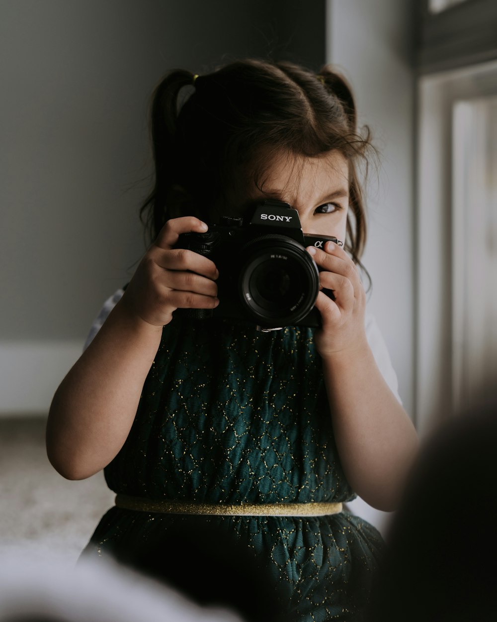 a little girl holding a camera up to her face