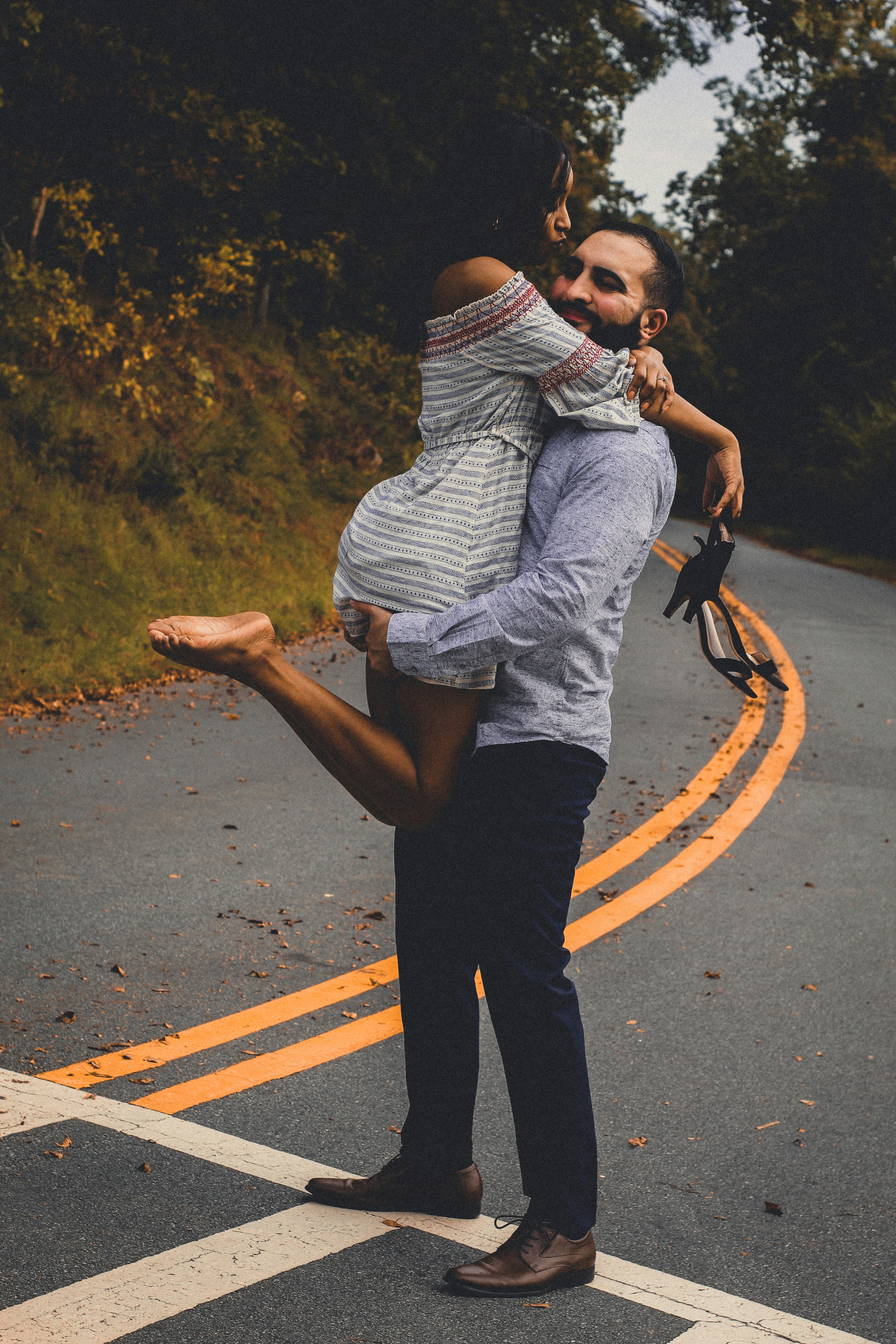 a man carrying a woman across a street
