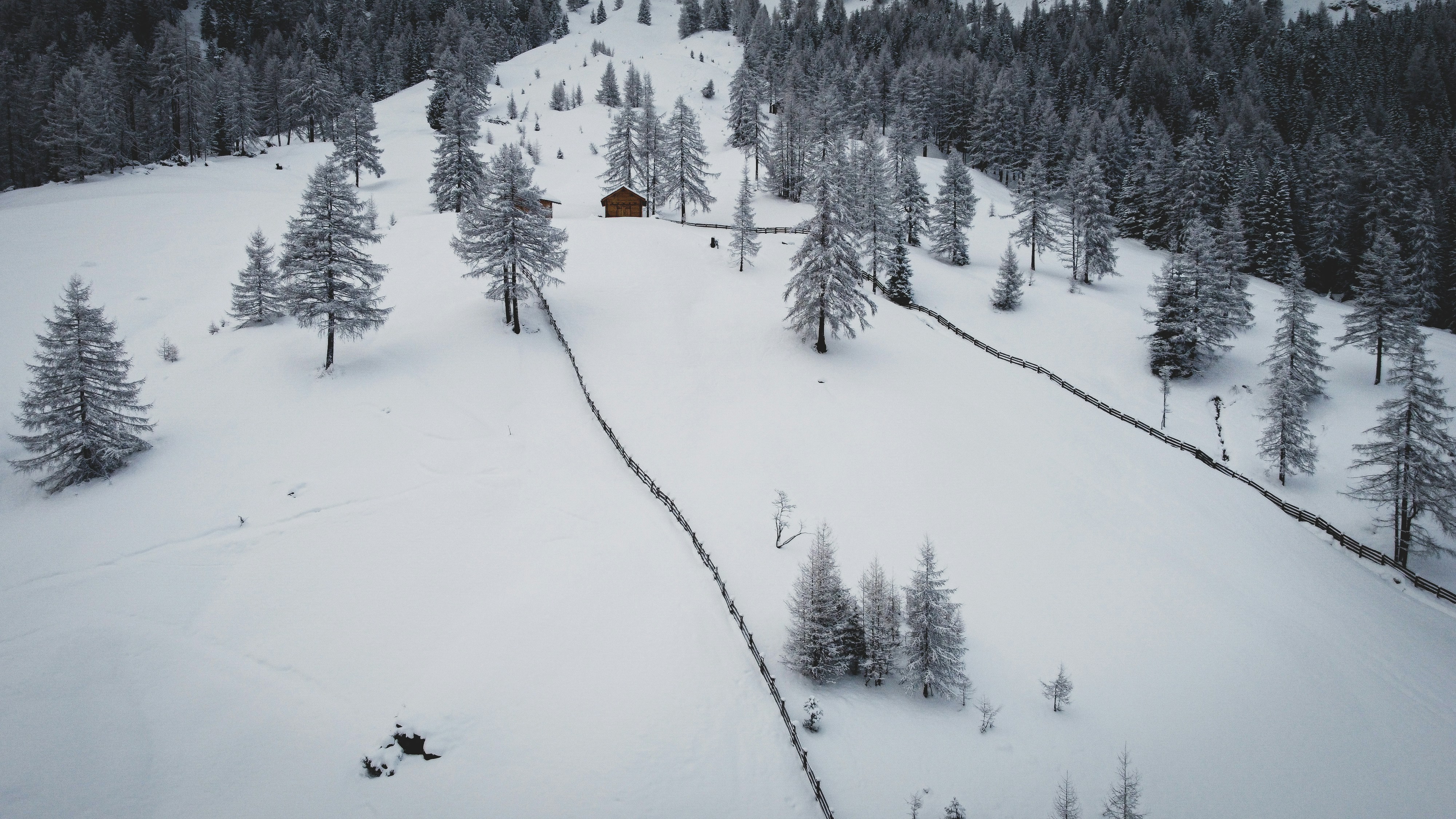 a snow covered mountain with a small cabin on top of it