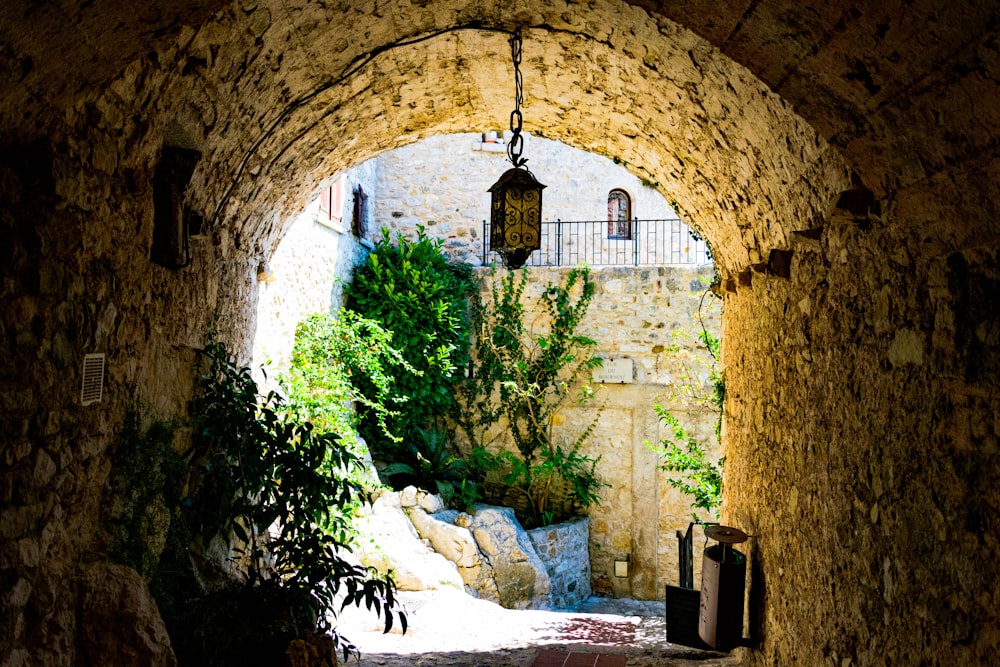 a stone tunnel with a light hanging over it