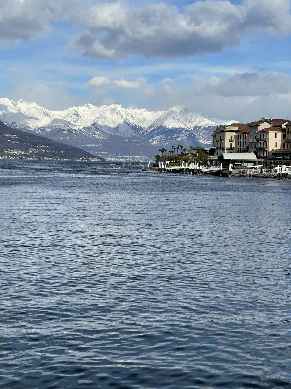 a body of water with houses and mountains in the background