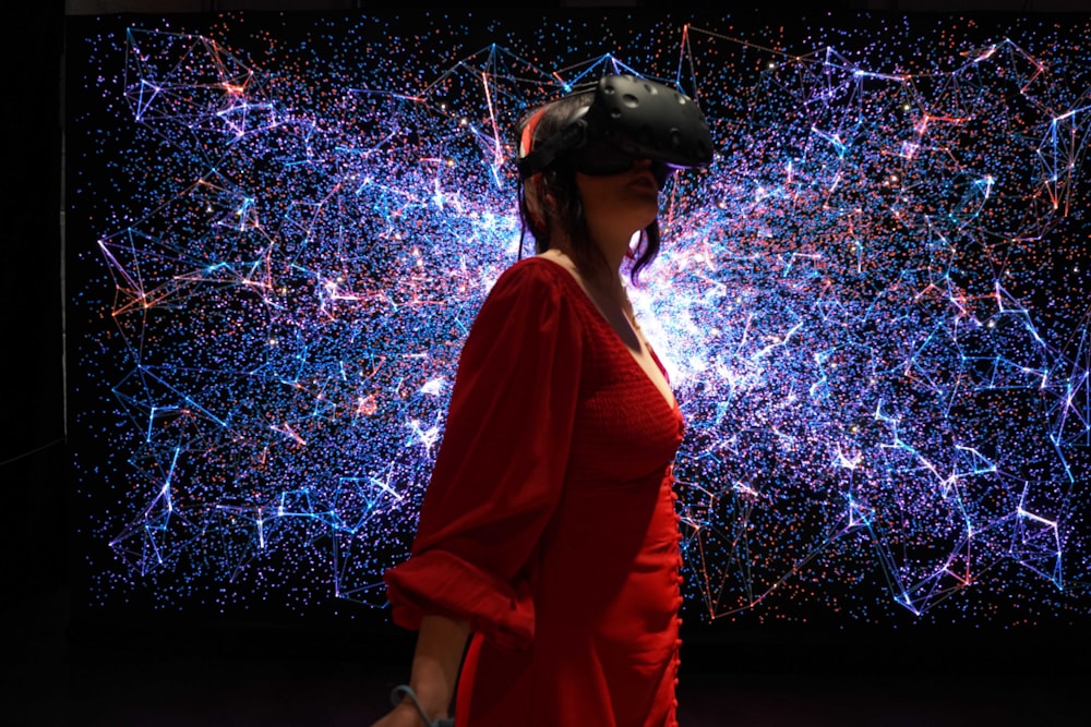 uma mulher em um vestido vermelho vestindo um fone de ouvido de realidade virtual