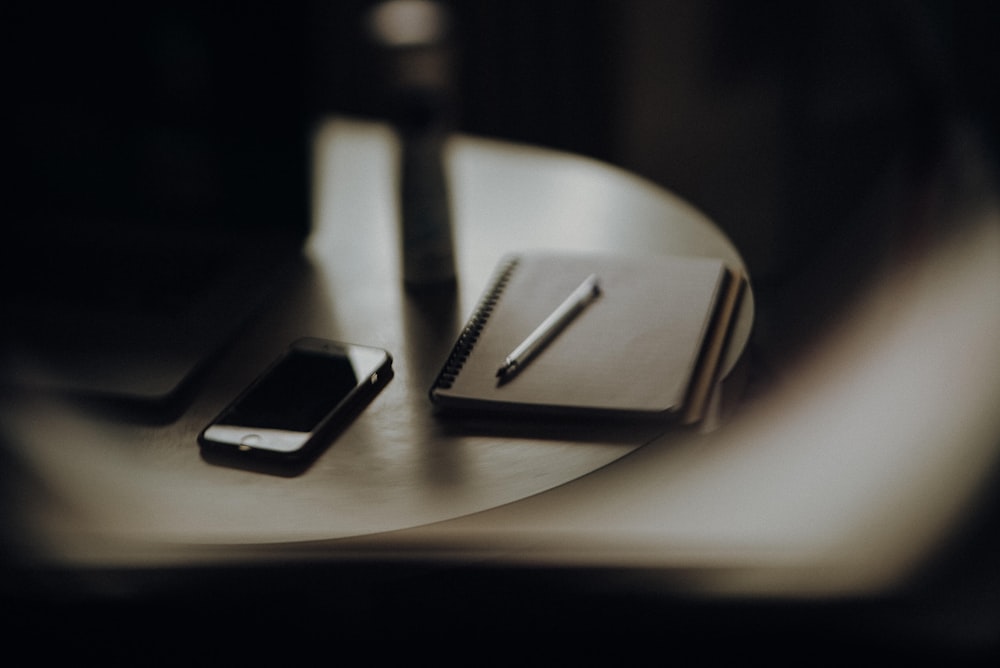 a cell phone and a notebook on a table