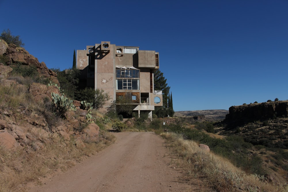 a dirt road with a building on the side of it