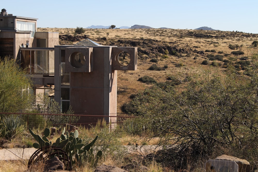 a building in the middle of a desert with mountains in the background