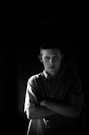 a man standing in a dark room with his arms crossed