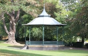 a gazebo in the middle of a park surrounded by trees