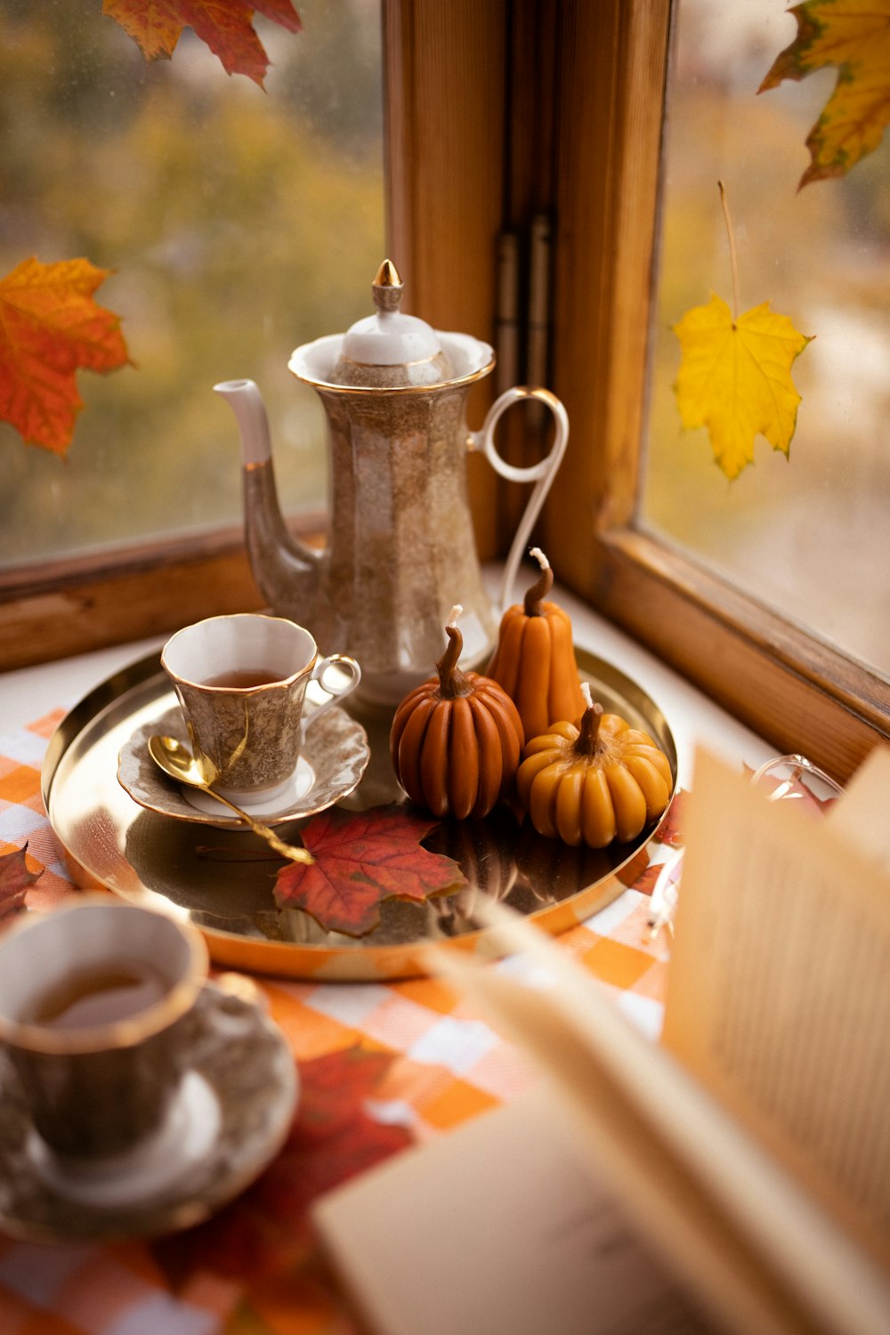 a tray with a tea pot, a cup of coffee and a book on it