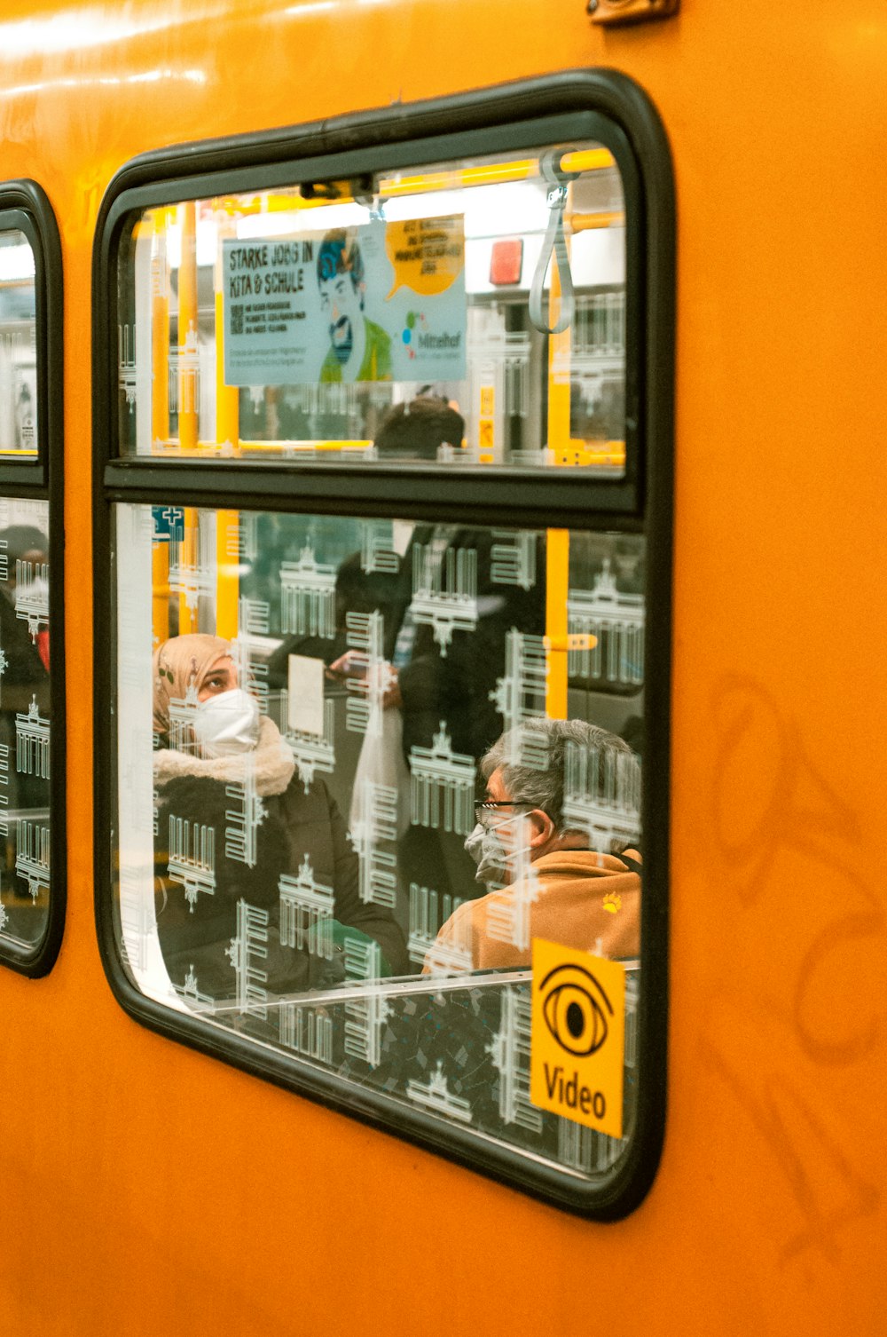 the reflection of people in the windows of a train