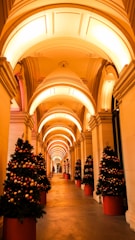 A warmly lit entrance archway glowing with classic holiday colors, welcoming visitors to the trail.