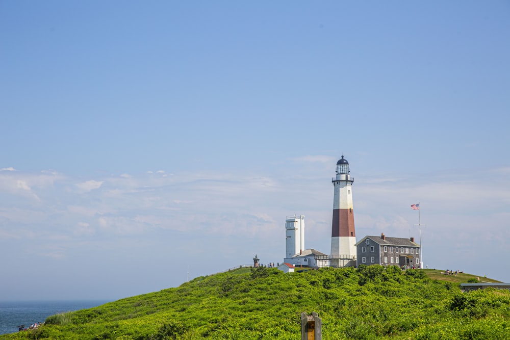 a lighthouse on top of a grassy hill