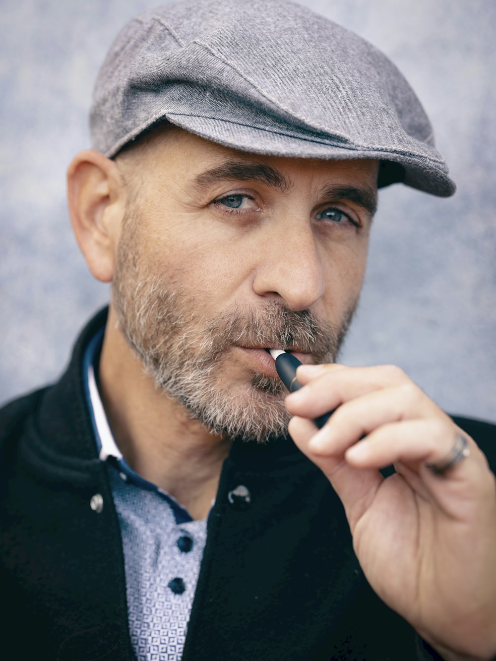 a man in a hat is smoking a cigarette