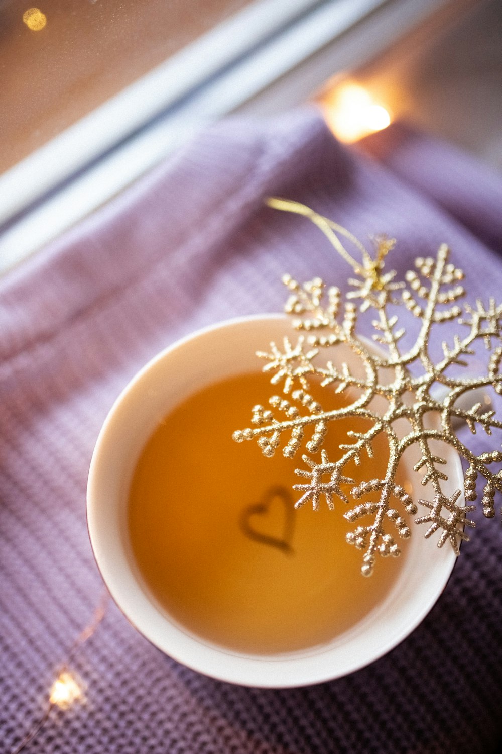 a cup of tea with a snowflake decoration in it