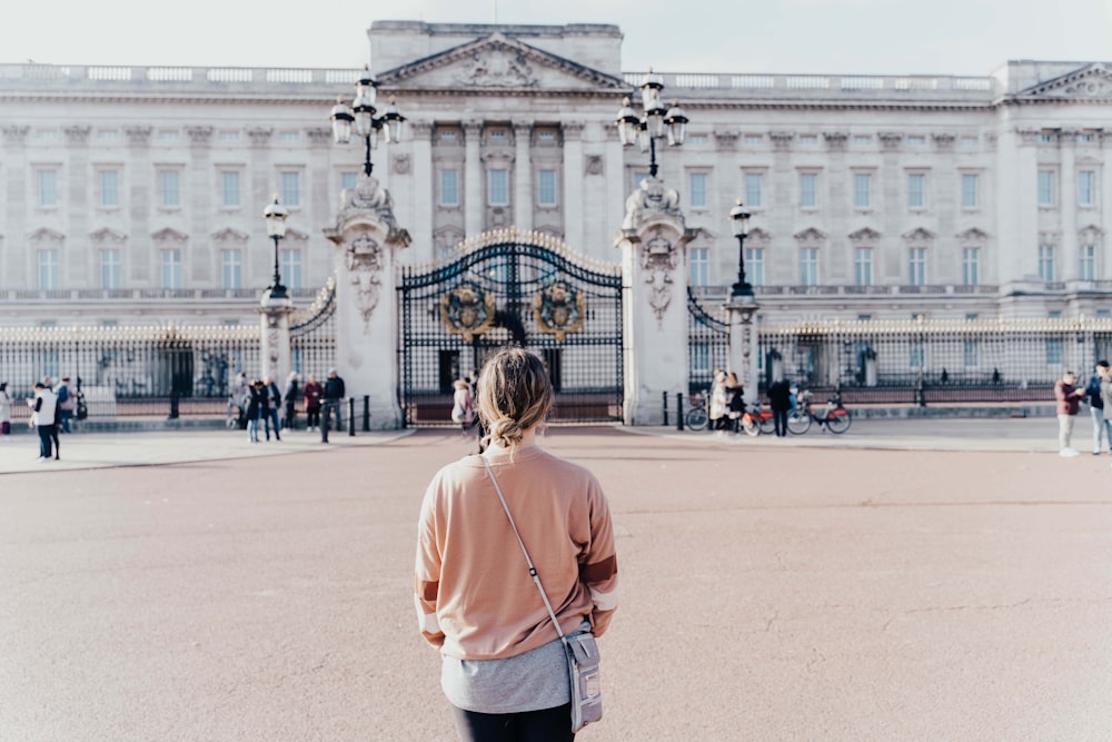 a woman standing in front of a large building