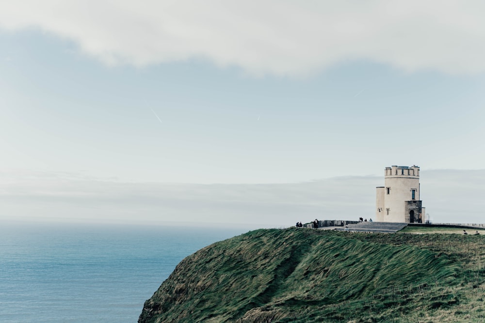 a lighthouse on a hill overlooking the ocean