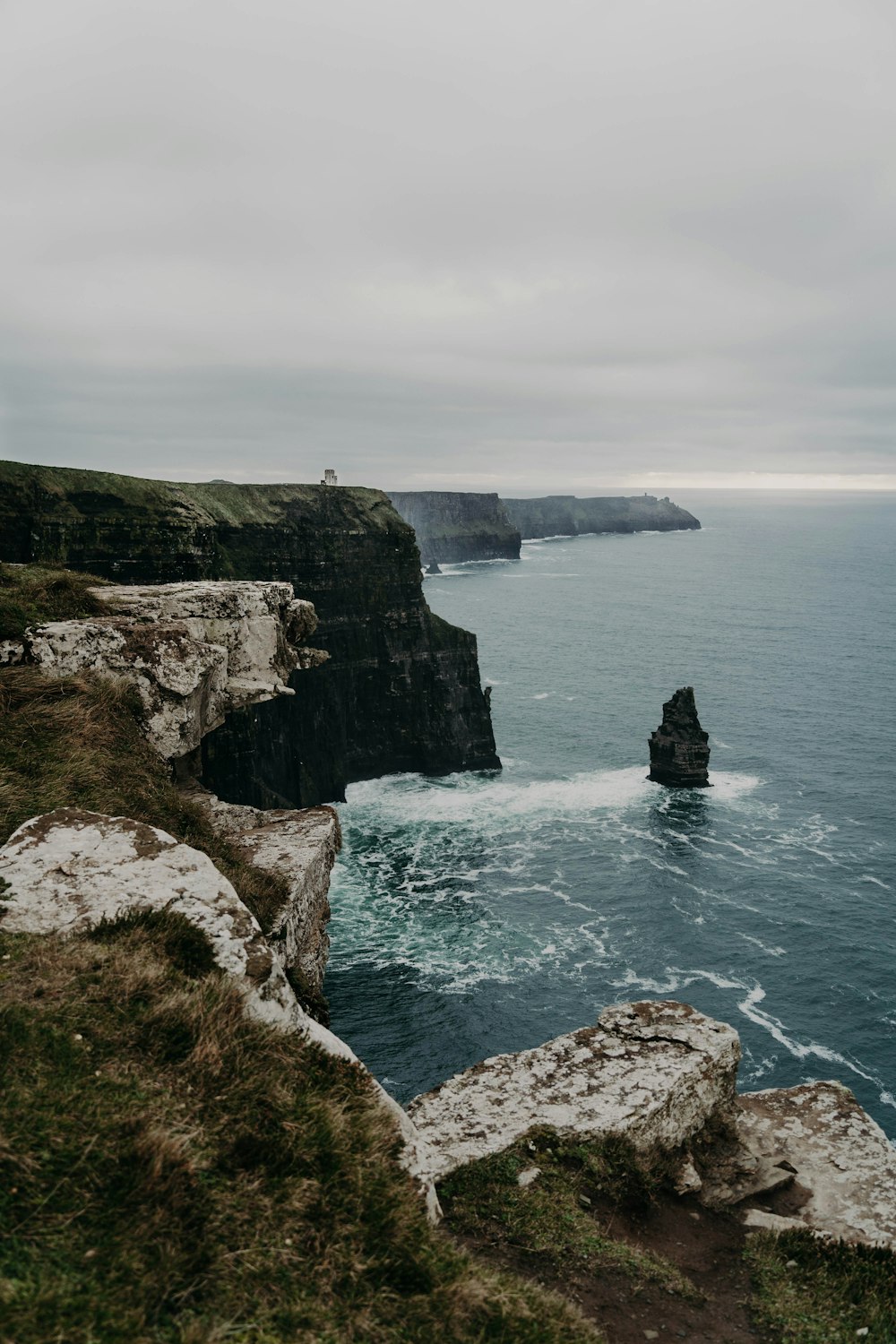 a large body of water next to a rocky cliff