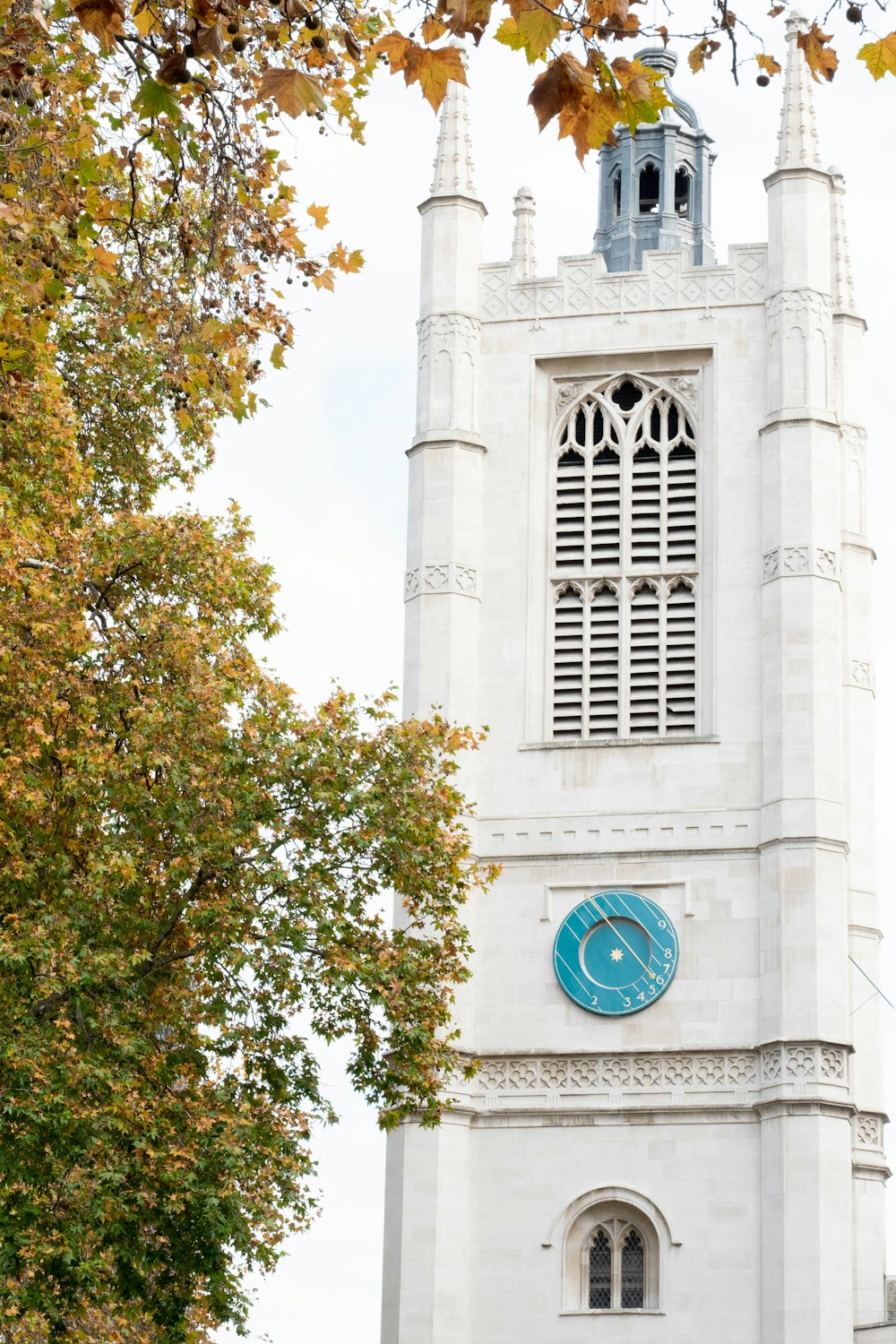 a tall white tower with a clock on it's side