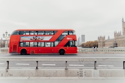 a red double decker bus driving down a street