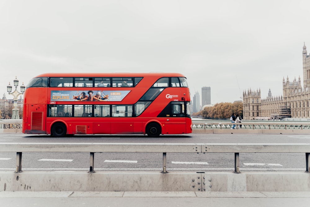 a red double decker bus driving down a street