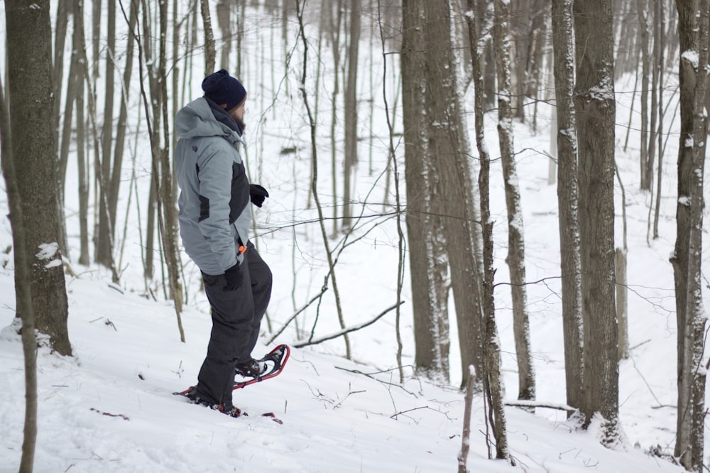 a man riding a snowboard down a snow covered slope