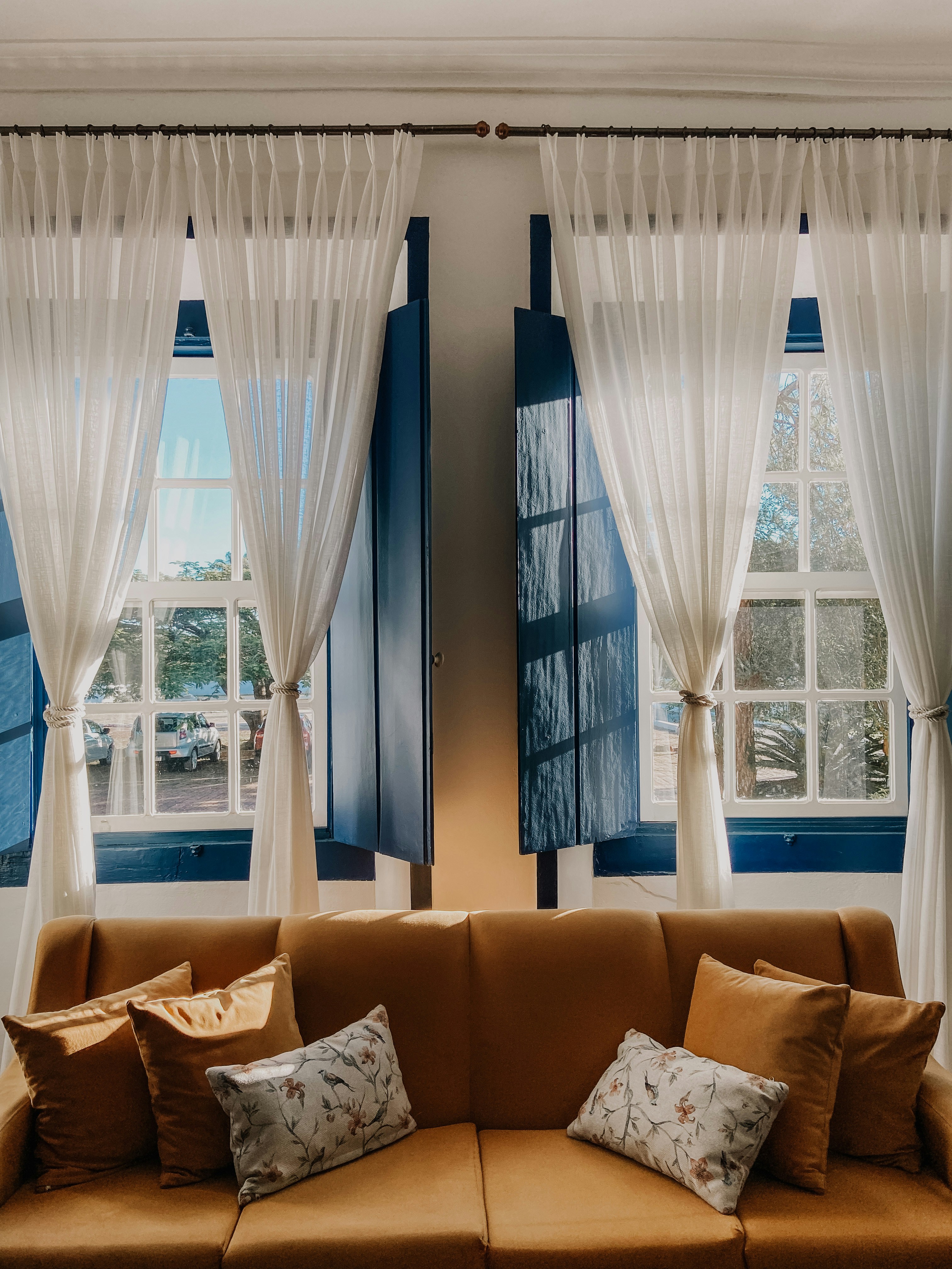 a brown couch sitting in front of two windows