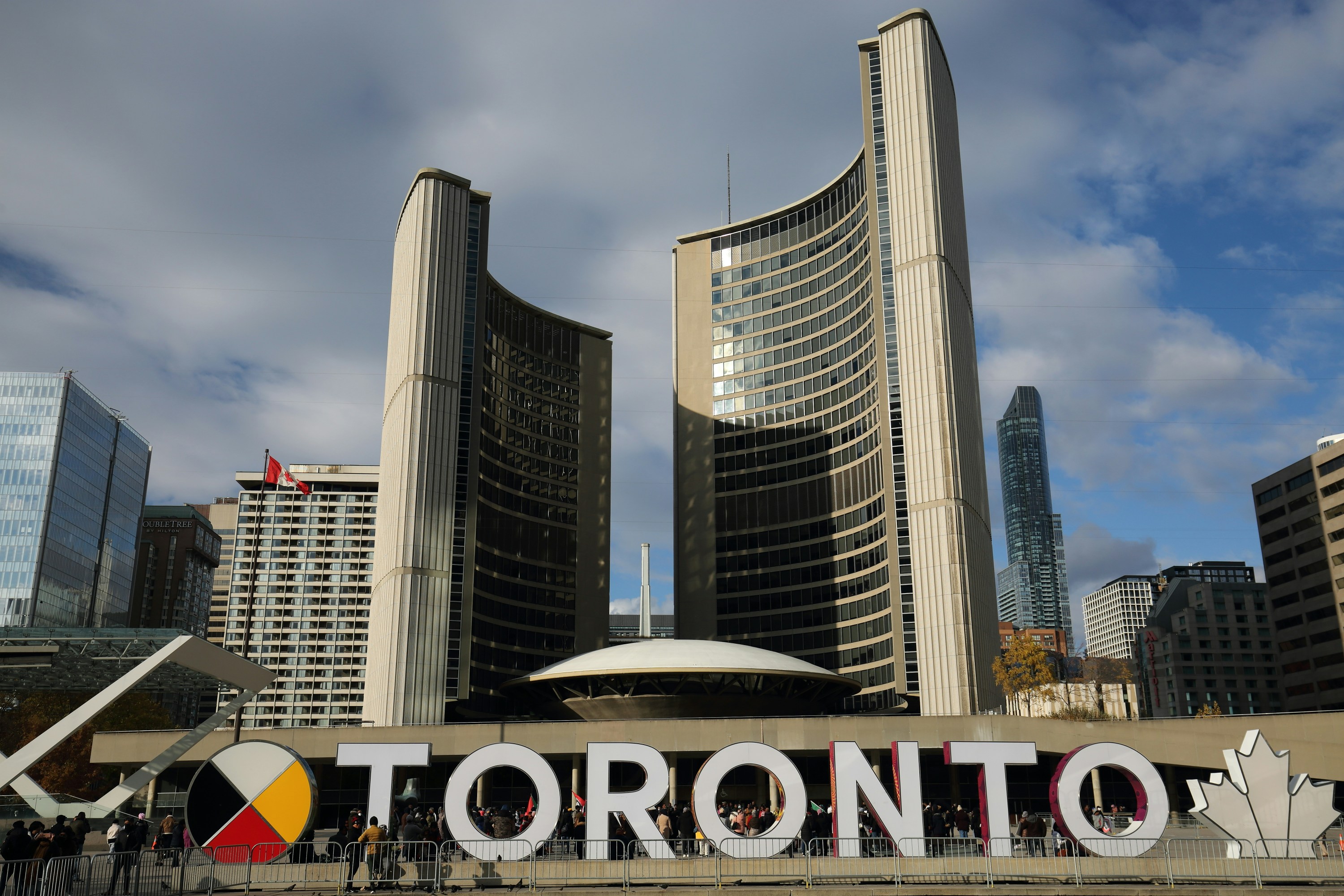 大きな看板の前に立つ人々のグループ