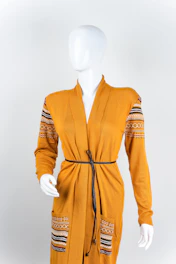 Mustard yellow high-waisted vintage trousers paired with a faded charcoal knit sweater on a retro-inspired mannequin.