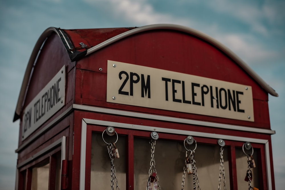 a red phone booth with a sign that says 2pm telephone