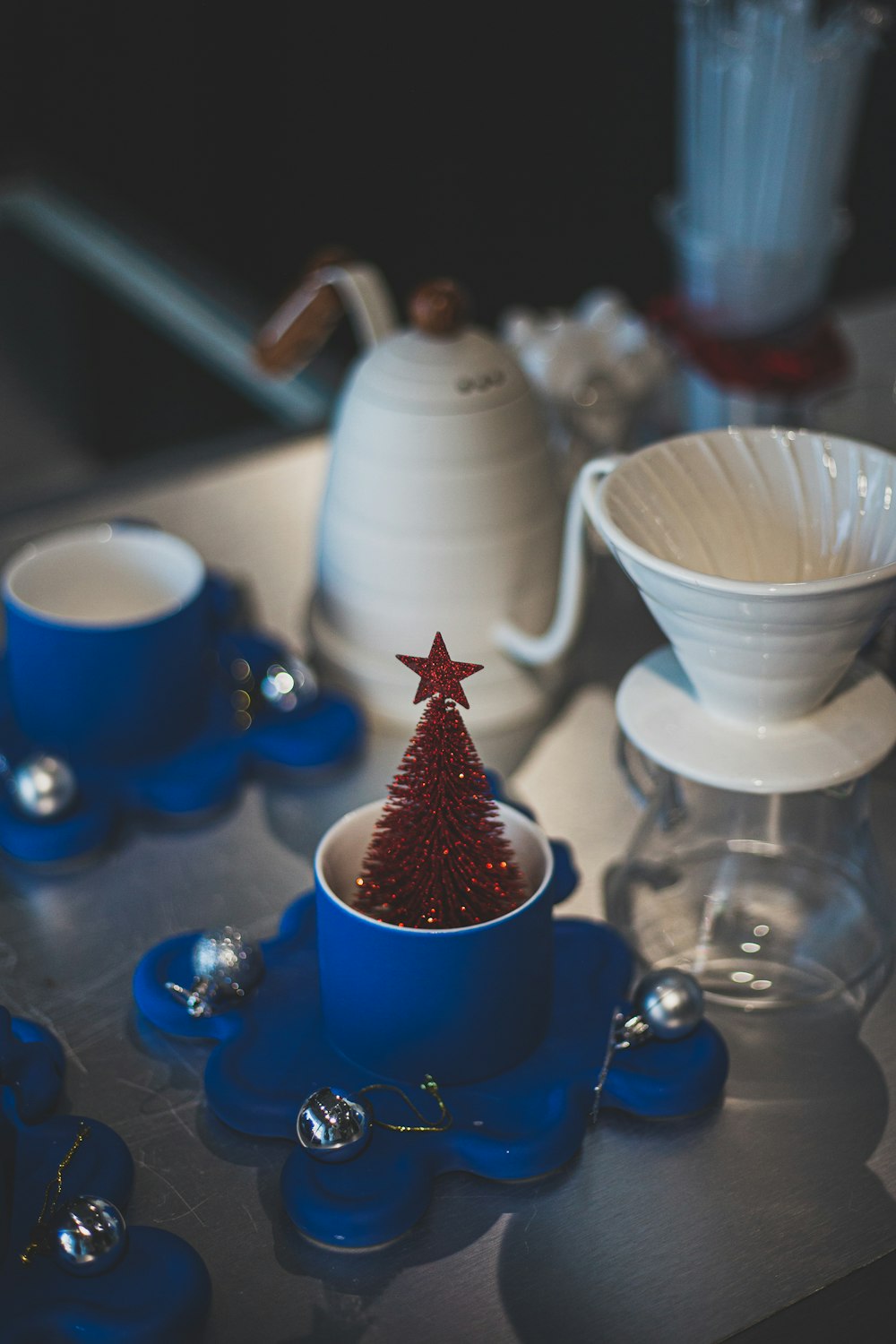 a small red christmas tree in a blue cup