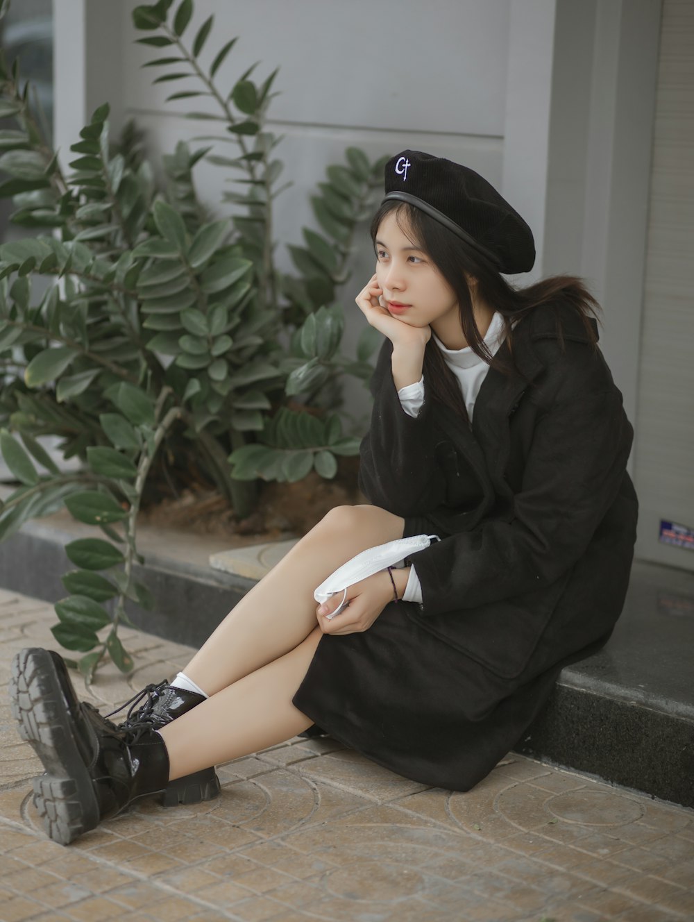 a woman sitting on the ground with a hat on