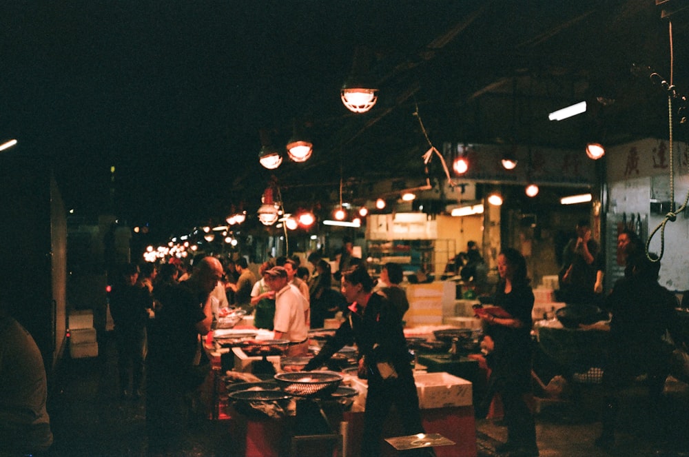 a group of people standing around a food market
