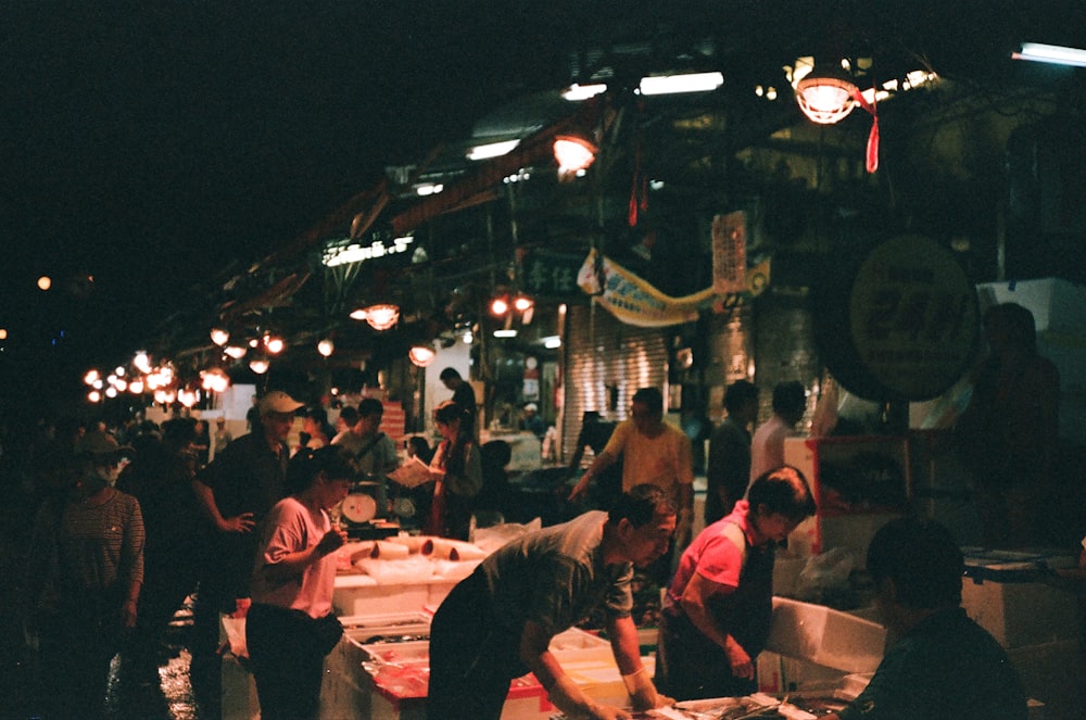 a group of people standing around a food market