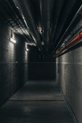 a dark tunnel with a red light at the end