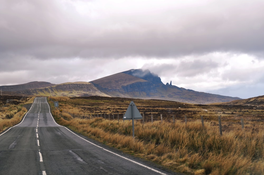 an empty road with a mountain in the background